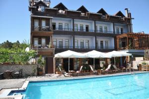 ein Hotel mit einem Schwimmbad vor einem Gebäude in der Unterkunft Kurfal Hotel in Agva + 14 Fotos