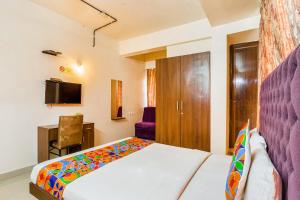 1 dormitorio con 1 cama, escritorio y TV en FabHotel Astra Suites HSR Layout, en Bangalore