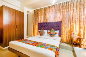 a bedroom with a bed and a large window at FabHotel Astra Suites HSR Layout in Bangalore