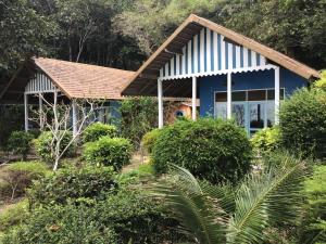 una casa azul en medio de un jardín en Heaven Beach Resort & Art, en Ko Phayam