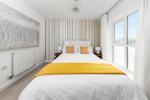 a white bedroom with a large bed with yellow blanket at Royal House Wolverhampton - Perfect for Contractors & Large Groups in Wolverhampton