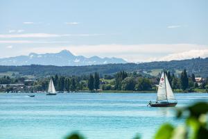 two sailboats on a lake with mountains in the background at Lakeside Apartment in Allensbach