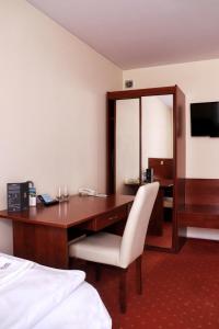 a hotel room with a desk with a chair and a bed at Hotel Gordon in Warsaw