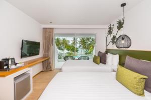 a hotel room with two beds and a television at La Vida Samui in Chaweng