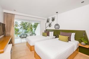 a hotel room with two beds and a balcony at La Vida Samui in Chaweng