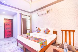 una camera con letto e murale di FabHotel 7 Nights Jagatpura a Jaipur