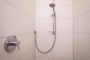 a shower in a white tiled bathroom at Ferienhof Weber Wohnung Fichte in Neukirch