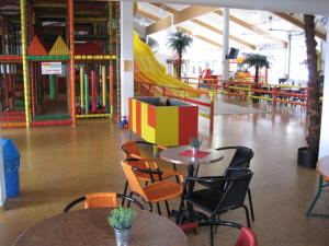 an empty play area with tables and chairs and a playground at Appartements im Predigtstuhl Resort in Sankt Englmar +19 photos
