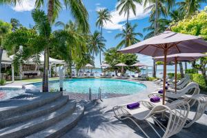 a pool at the resort with chairs and an umbrella at La Vida Samui in Chaweng