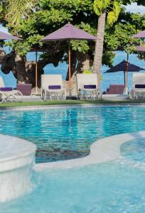a swimming pool with chairs and umbrellas at La Vida Samui in Chaweng