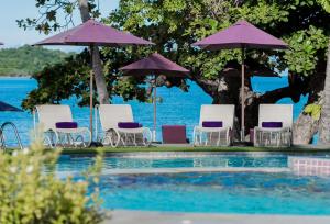 a group of chairs and umbrellas next to a pool at La Vida Samui in Chaweng