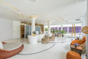 a lobby with chairs and tables in a building at La Vida Samui in Chaweng