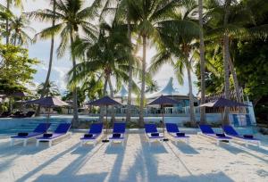 a group of blue chairs and umbrellas on a beach at La Vida Samui in Chaweng