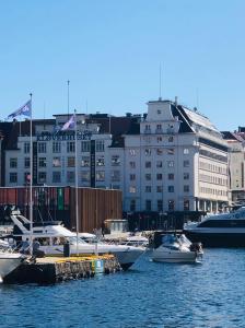a group of boats docked in a harbor with buildings at Magic Hotel & Apartments Kløverhuset in Bergen