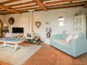 a living room with a blue couch and a table at Coinage Hall in Lostwithiel