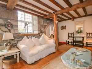 a living room with a white couch and a table at Coinage Hall in Lostwithiel