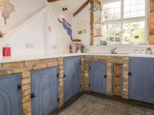 a kitchen with blue cabinets and a sink at Coinage Hall in Lostwithiel +18 photos