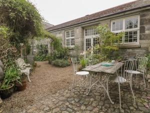 a garden with a table and chairs in front of a building at Coinage Hall in Lostwithiel