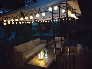 a patio with a couch and a table with lights at Mendei Vendégház in Mende