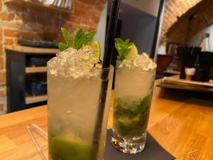 two cocktails sitting on a wooden table at Apartamenty Wałowa 4 in Tarnów