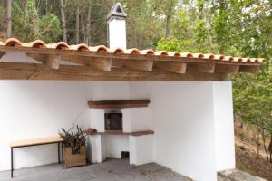 a wooden roof on a white building with a fireplace at Casa do Caminheiro in Lousã