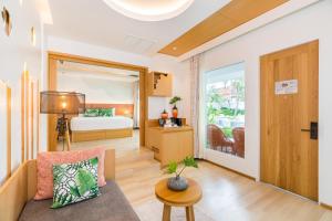 a living room with a couch and a bed at La Vida Samui in Chaweng
