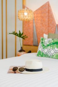 a hat and sunglasses sitting on top of a bed at La Vida Samui in Chaweng