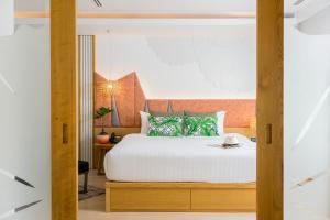 a bedroom with a white bed with a wooden headboard at La Vida Samui in Chaweng