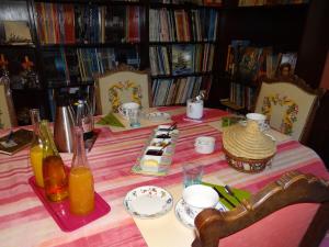 uma mesa com uma toalha de mesa rosa e branca listrada em Manoir familial de la Provosterie em Ahuillé