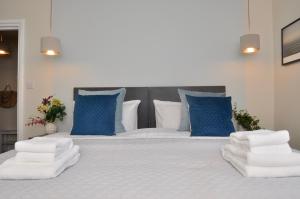 a large bed with blue and white pillows on it at Bridge Street Apartments. Boutique Style Luxury, in the heart of Taunton. in Taunton