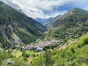 un village dans une vallée dans les montagnes dans l'établissement Résidence Saint-Jean, à Saint-Dalmas-le-Selvage