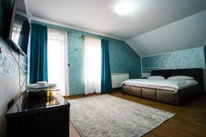 1 dormitorio con 1 cama y paredes azules en Perla Nordului, en Moisei