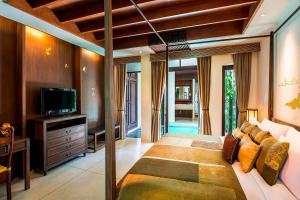 um quarto com uma cama grande e uma televisão em The Lamai Samui em Lamai