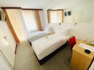 Habitación de hotel con 2 camas y escritorio en Hotel Slavonija en Vinkovci