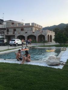 Quelques personnes assises dans un bassin d'eau dans l'établissement residenza monarka, à Marina di Davoli