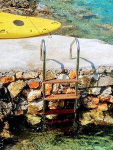 a bench in the water next to a surfboard at Villa LeSunLuka Lefkada in Vasiliki