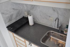um balcão de cozinha com um lavatório e uma torneira em Rob's Cottage em Schoorl