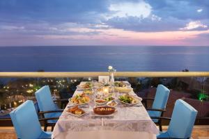 una mesa con comida en un balcón con vistas al océano en Merit Crystal Cove Hotel Casino & SPA, en Kyrenia