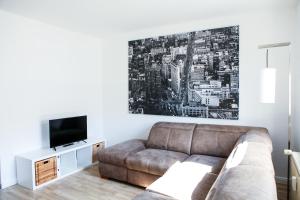 a living room with a couch and a tv at Apartment "New York" in Korschenbroich