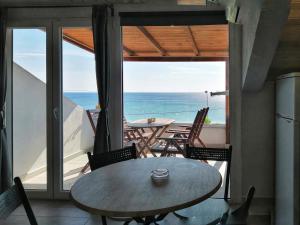 a table and chairs on a balcony with the ocean at Isalos in Velika