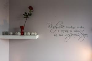 un vase avec une fleur sur un mur dans l'établissement Apartamenty Izerskie, à Świeradów-Zdrój