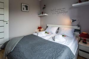 1 dormitorio con 1 cama con sábanas y almohadas blancas en Apartamenty Izerskie, en Świeradów-Zdrój