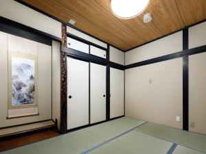 een kamer met witte muren en een houten plafond bij Connect inn Gion-Bishamoncho in Kyoto