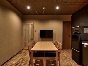 een eetkamer met een tafel, stoelen en een tv bij Connect inn Gion-Bishamoncho in Kyoto