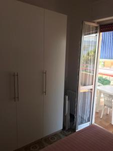 1 dormitorio con armarios blancos y puerta corredera de cristal en Sul mare, en Silvi Marina