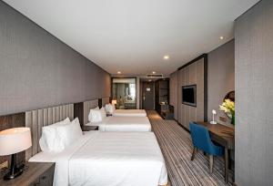 Postel nebo postele na pokoji v ubytování Muong Thanh Luxury Saigon Hotel