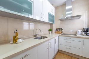 a kitchen with white cabinets and a sink at Apartamento Sofia Ronda Center in Ronda
