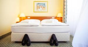 Victor's Residenz-Hotel Gera في غيرا: سرير أبيض كبير في غرفة الفندق