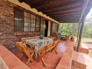 Un patio con una mesa y sillas en una casa. en Athule Inn Marloth - House, en Marloth Park