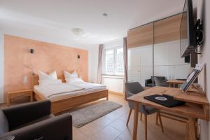 a bedroom with a bed and a desk with a computer at Märchenwald Altenberg B&B Hotel in Odenthal